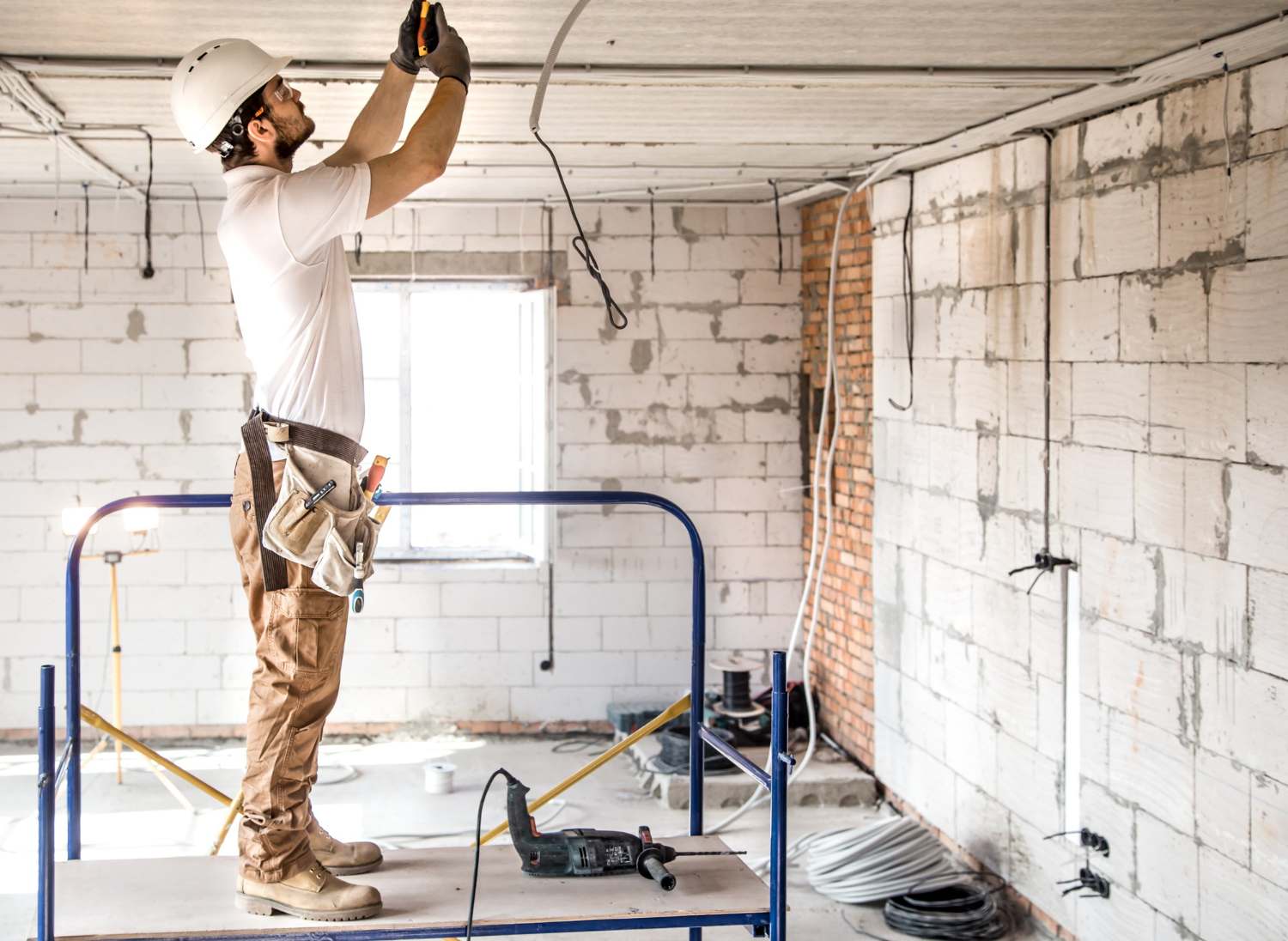 électricien travaillant avec des câbles sur le chantier de construction