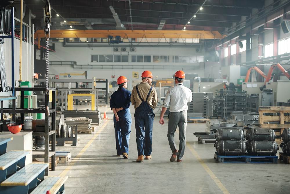 Vue de dos de trois jeunes travailleurs de l'industrie 